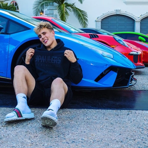 A picture of Jake Paul with his lavish cars. 